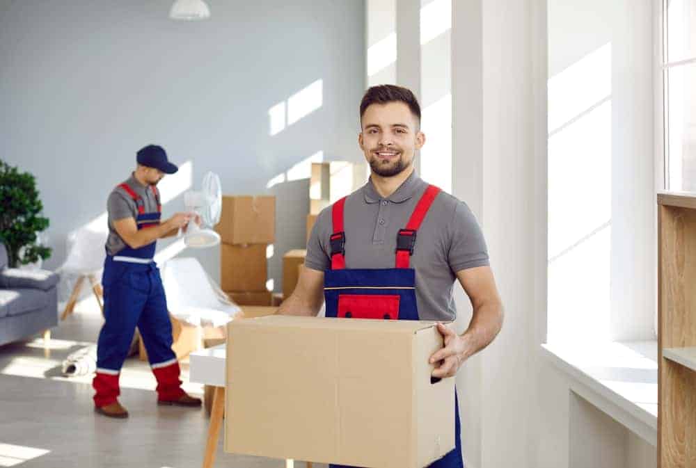 A person in overalls holding a box for moving office